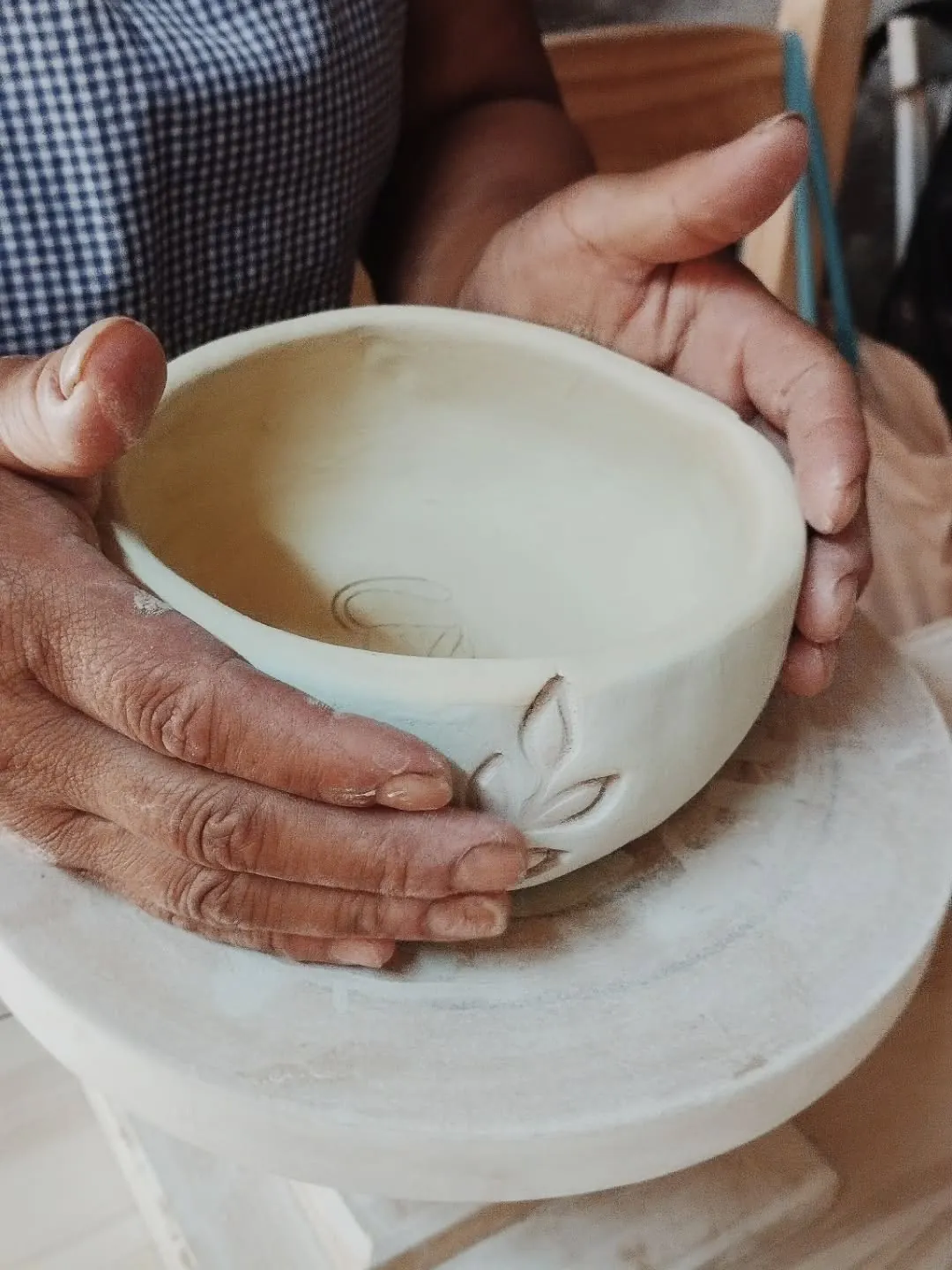 Manos moldeando cerámica en el taller Dayu